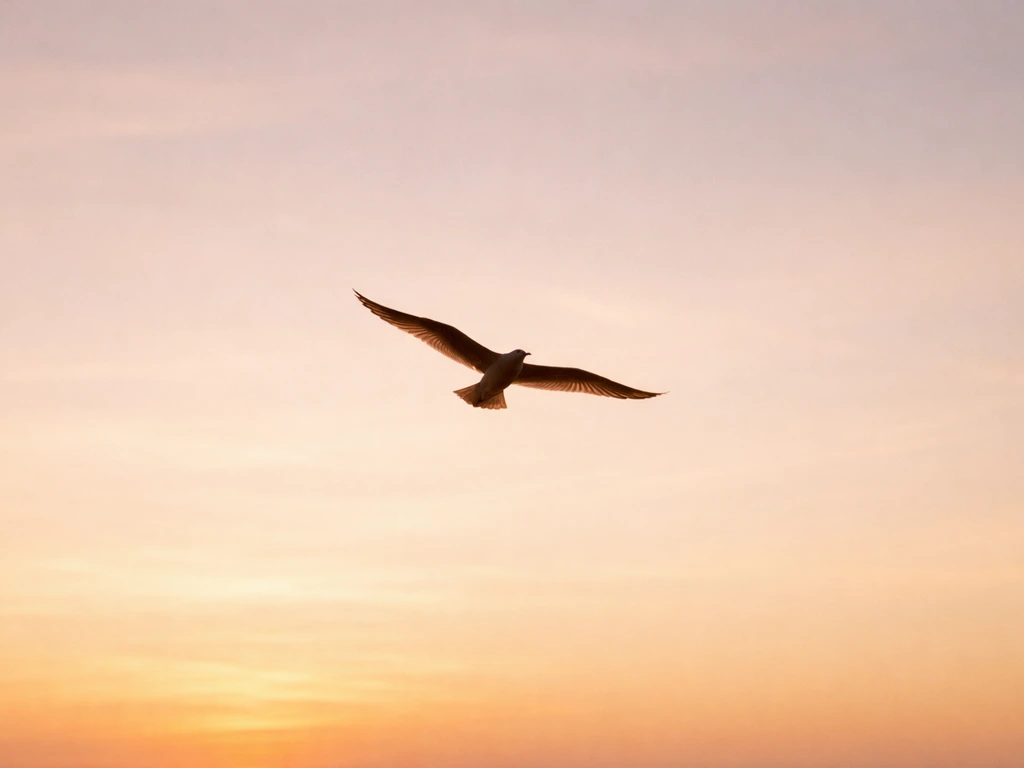 Golden-brown silhouette of a bird in flight against an open sky, symbolizing freedom and liberation.